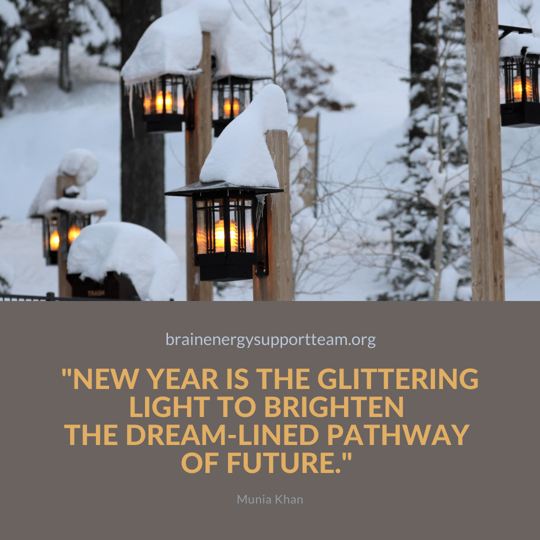 Lit lanterns hung on poles along a short snowy path