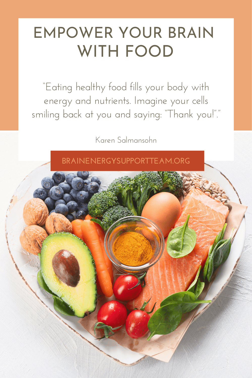 A photo of healthy brain foods in a heart shaped bowl: blueberries, nuts, avocado, carrots, tomatoes, eggs, olive oil (in a small glass container), broccoli, peas, grains